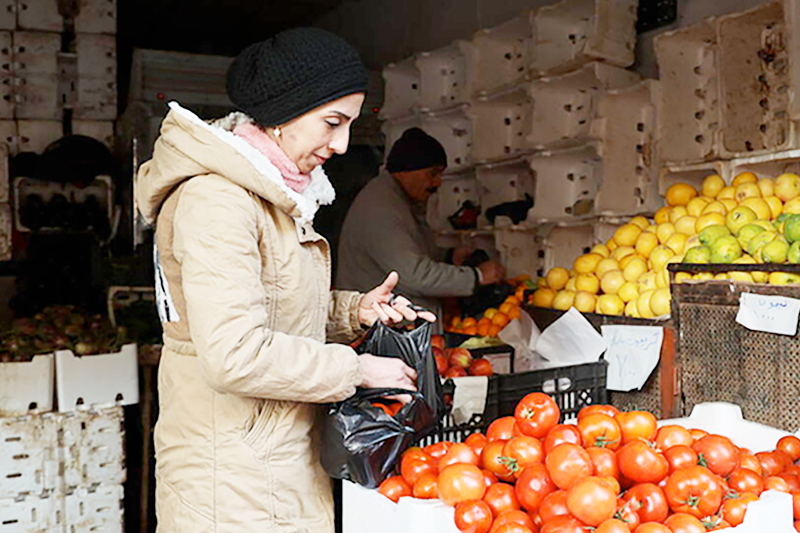 Rubin at a WFP contracted retailer buying fresh food for her family using the WFP voucher.