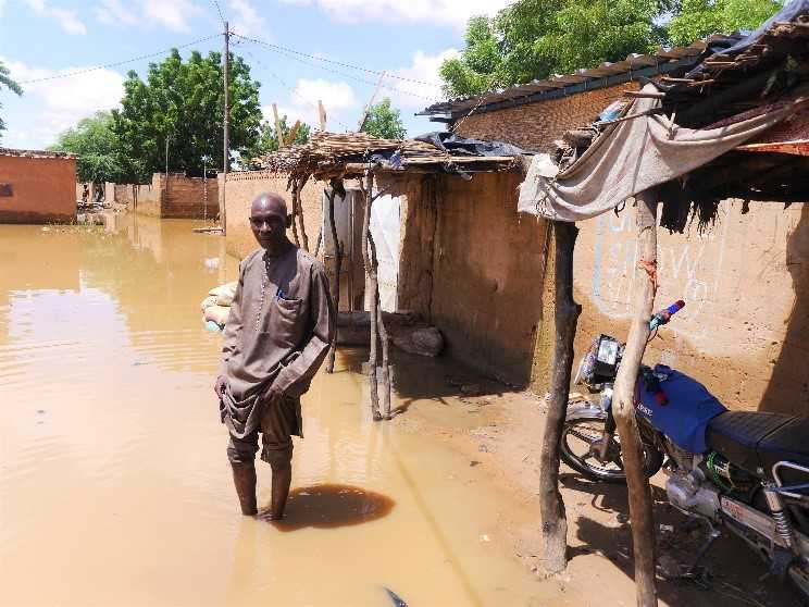 Mr. Belko Idi wades through stagnant water to enter his house. Kirkissoye, Niamey. 4 September 2020. Credit: OCHA/Abdoulaye Hamani