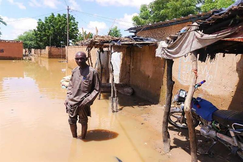 Belko Idi wades through stagnant water to enter his house in Kirkissoye, Niamey, Niger, 4 September 2020.